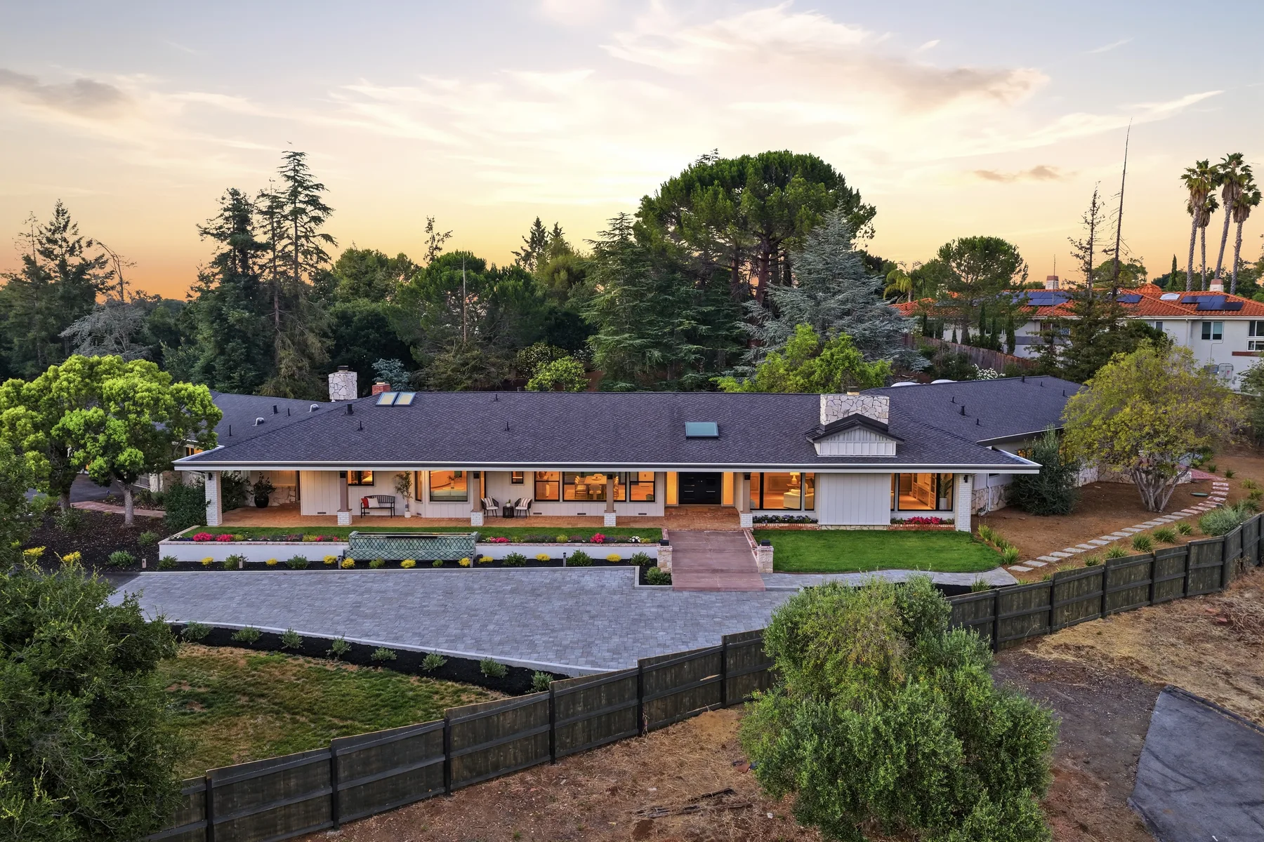 Aerial view of a single-story home and grounds at sunset.