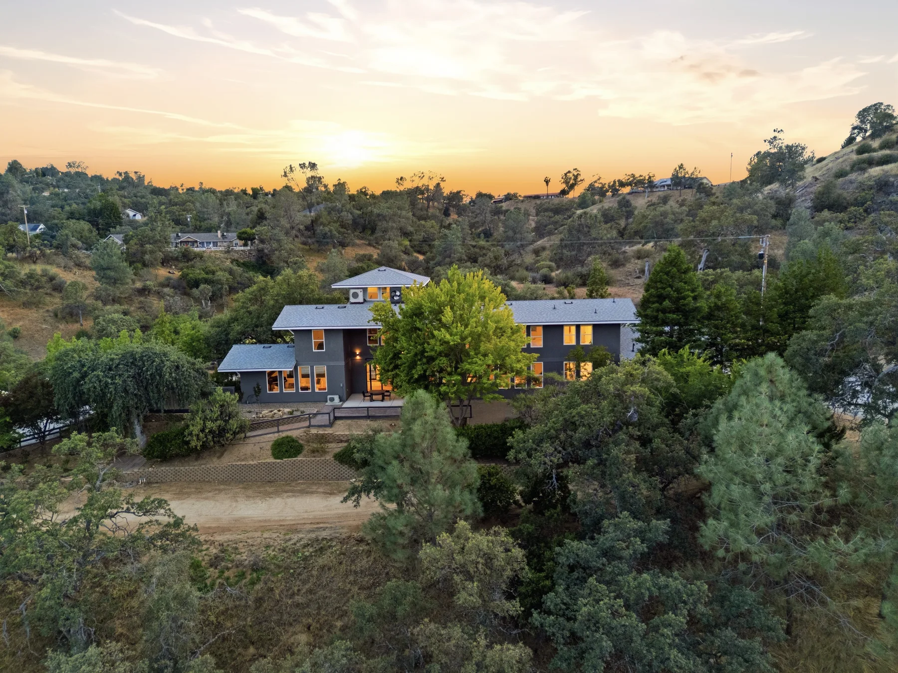 Aerial view of a hillside home at sunset.